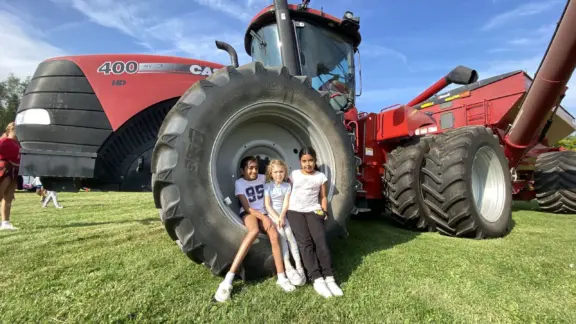 Sydenham-Fall-Fair-three-girls-in-tractor-wheel-SD-scaled-1
